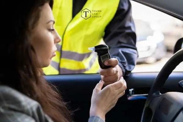 a woman being offered a breathalyzer test by a police officer